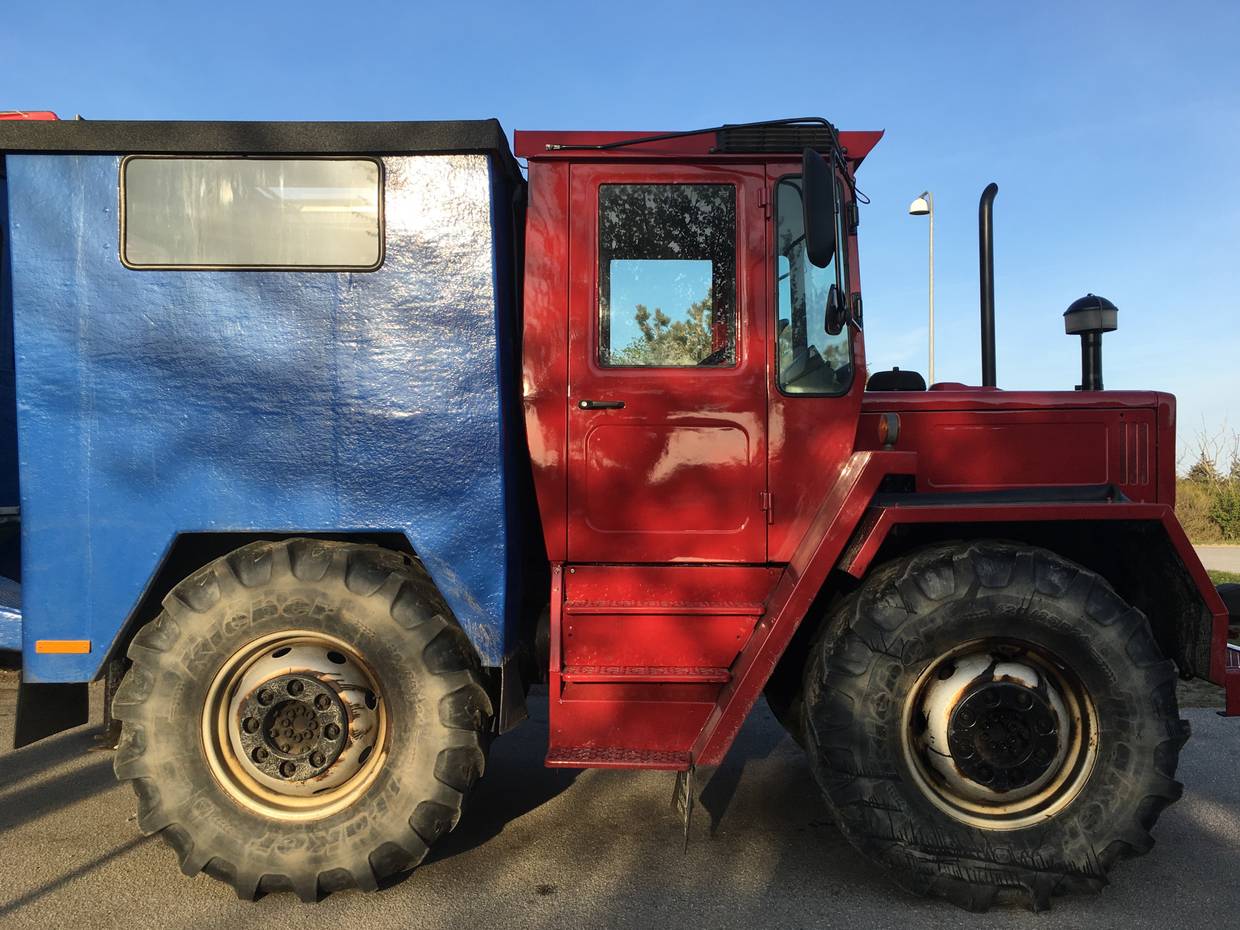 Roter Traktor mit Busaufbau