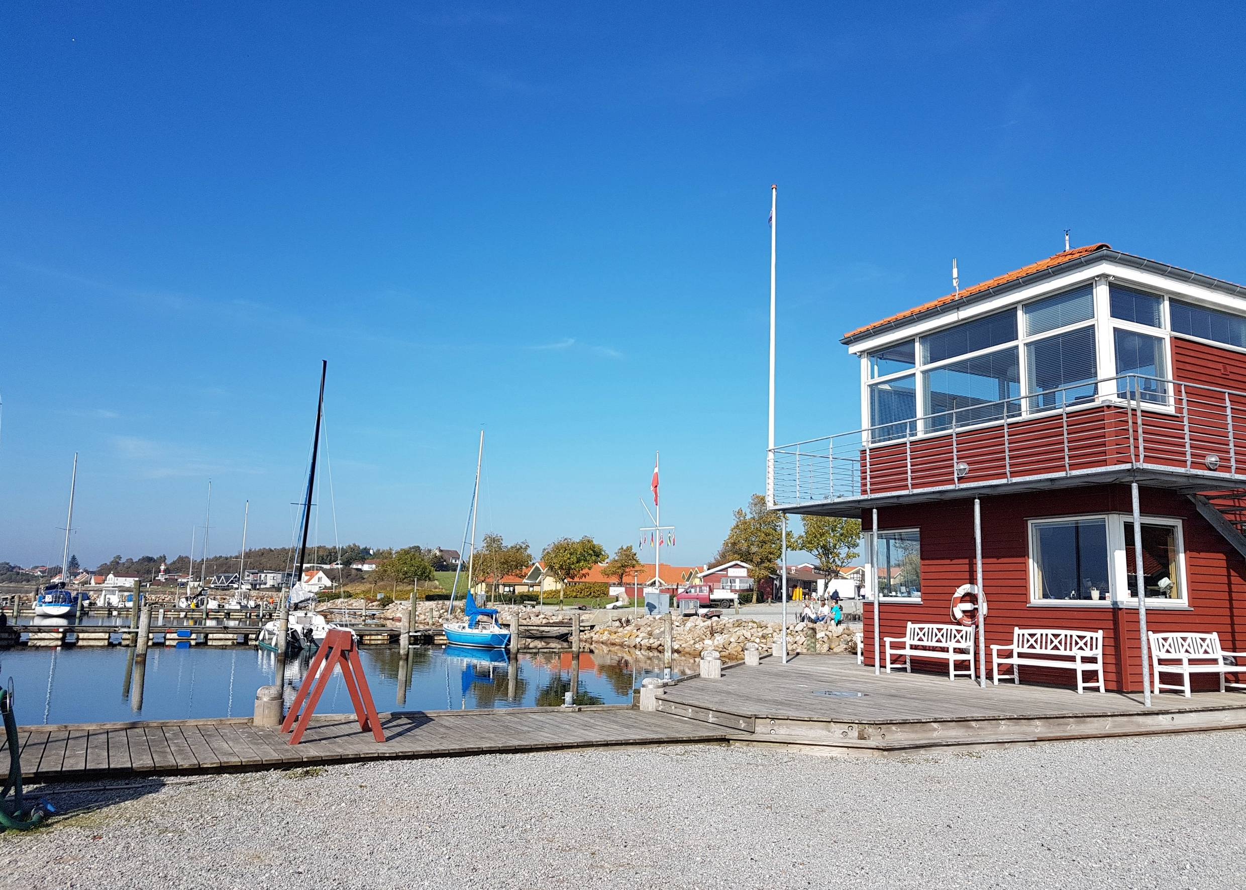Blick auf ein rotes Holzhaus am Jachthafen von Rendbjerg