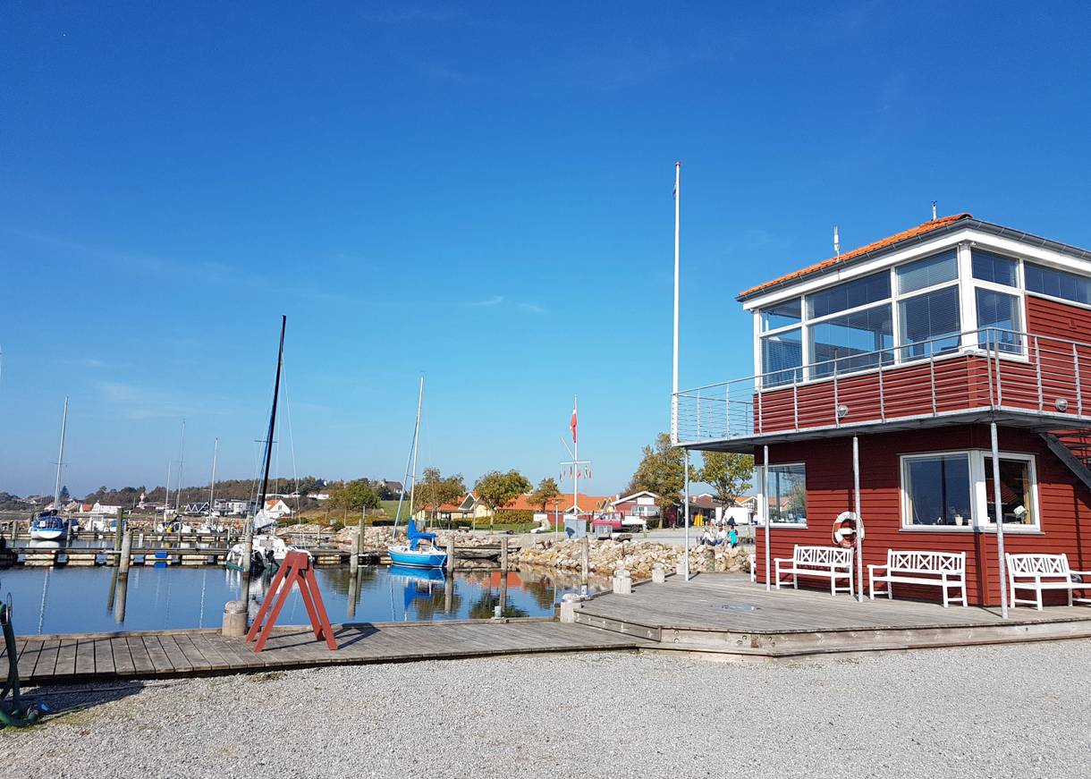 Blick auf ein rotes Holzhaus am Jachthafen von Rendbjerg