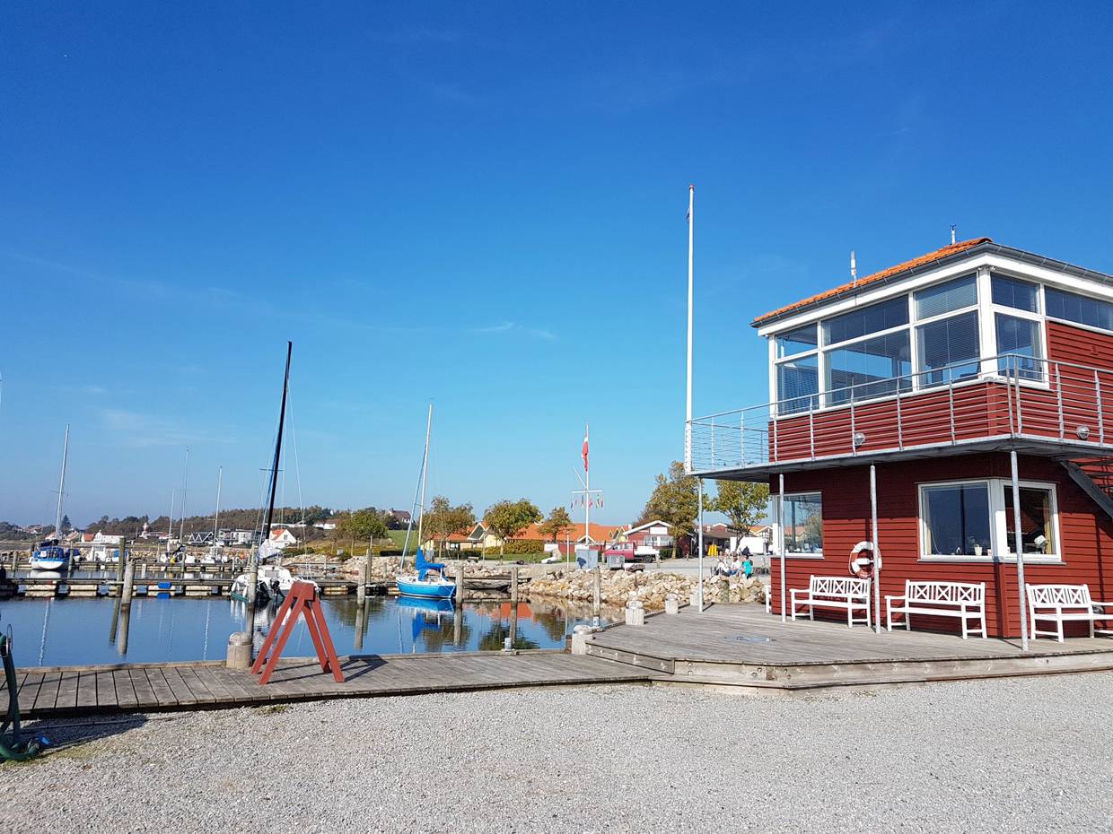 Blick auf ein rotes Holzhaus am Jachthafen von Rendbjerg