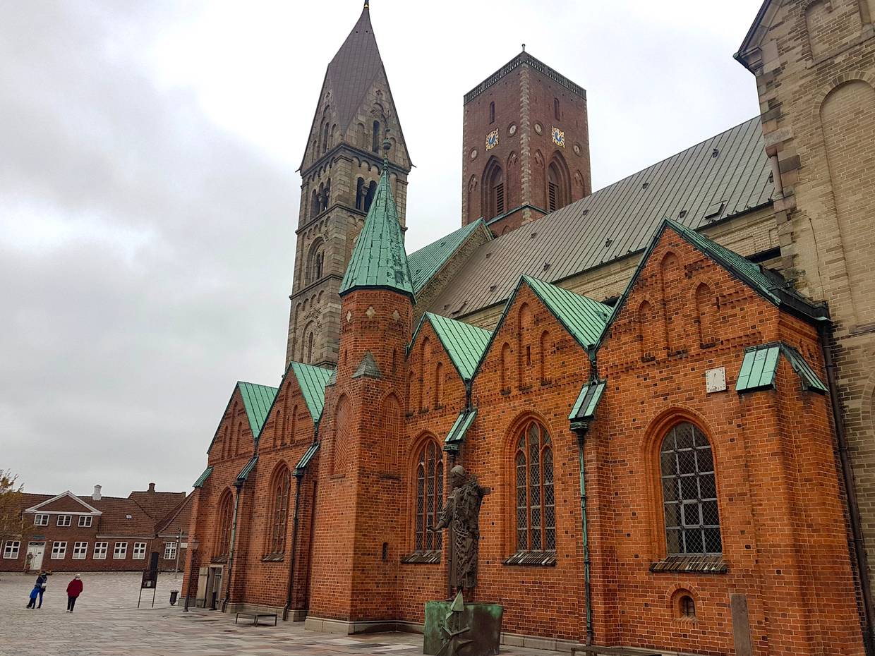 Seitenfront des Doms in Ribe, davor eine Bronzeplastik