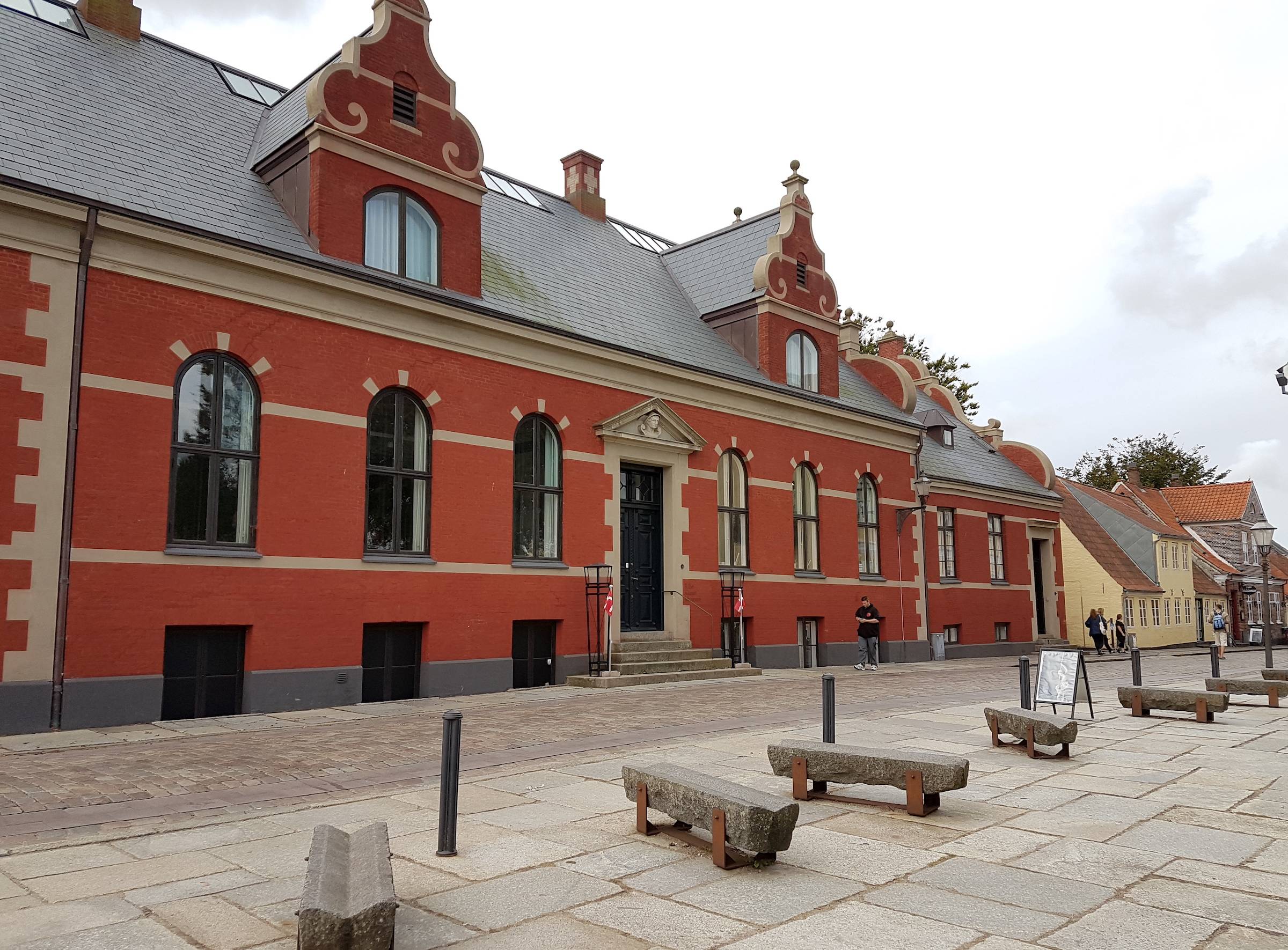 Rotes, langes Haus mit einer schnörkligen Fassade 