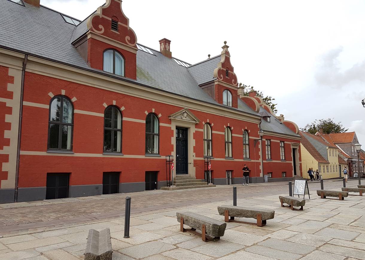 Rotes, langes Haus mit einer schnörkligen Fassade 