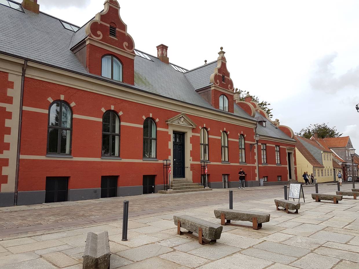 Rotes, langes Haus mit einer schnörkligen Fassade 