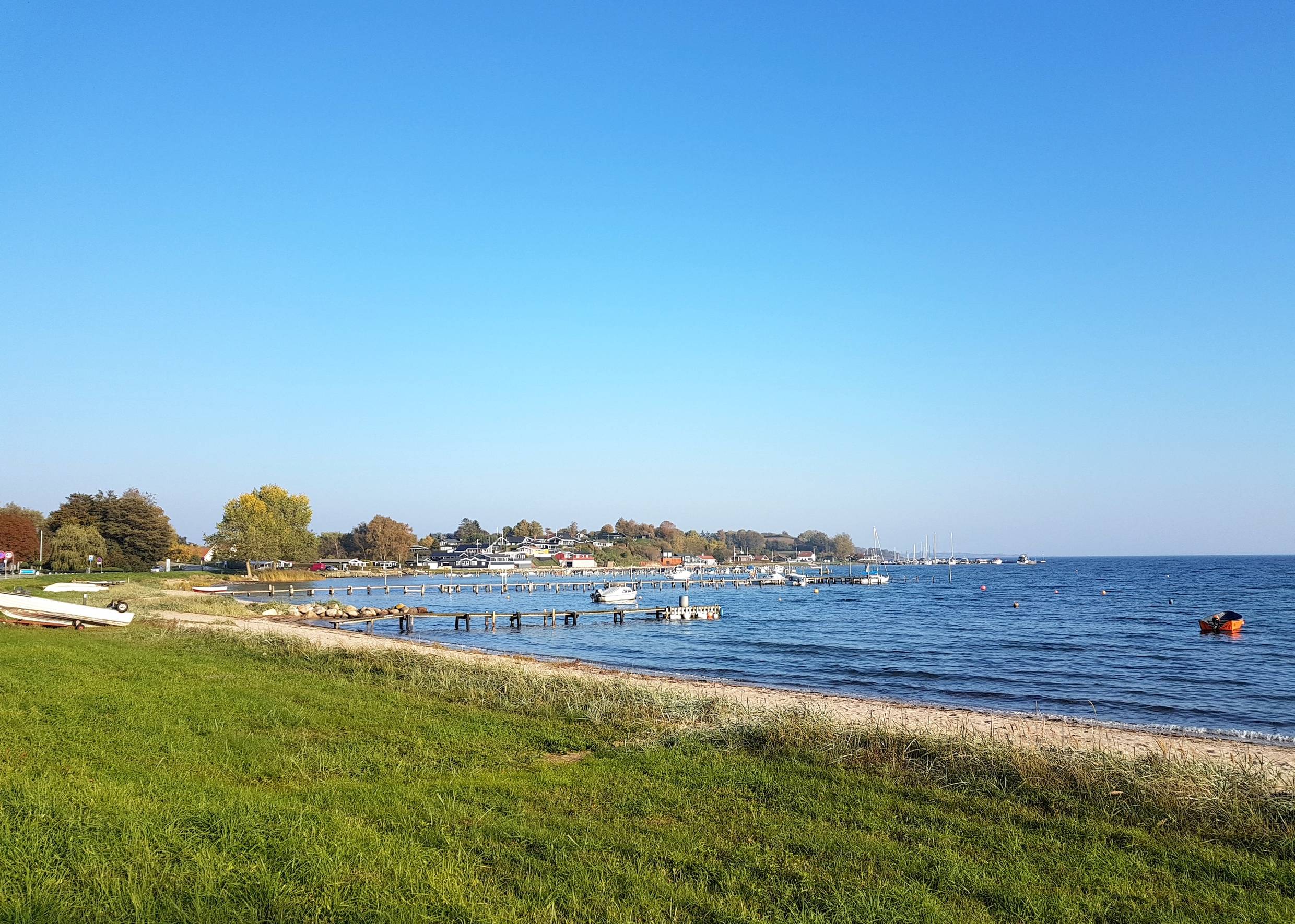 Blick über die Genner Bucht mit vielen Stegen und Ferienhäusern im Hintergrund