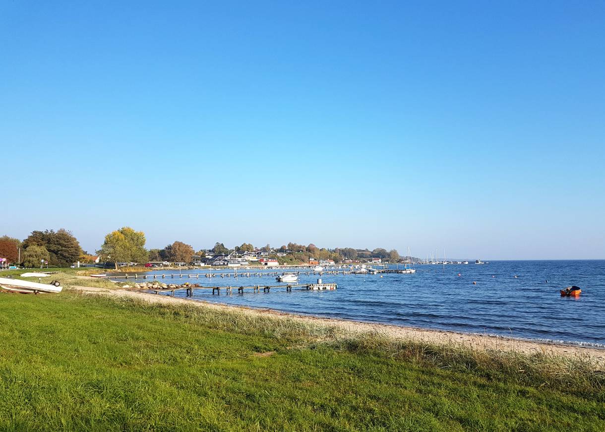 Blick über die Genner Bucht mit vielen Stegen und Ferienhäusern im Hintergrund