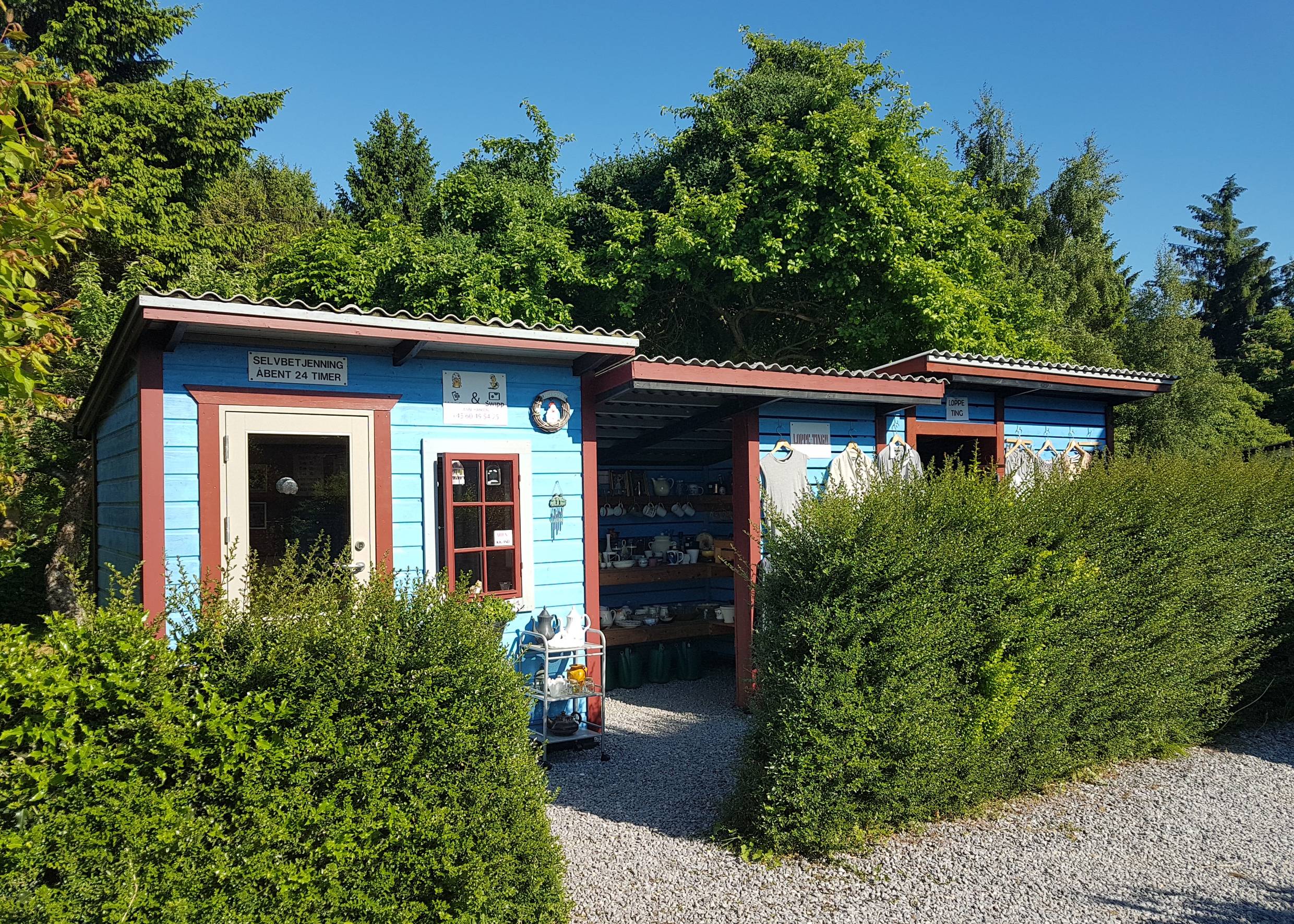 Farbig gestrichene Holzschuppen mit einem privaten Flohmarktstand