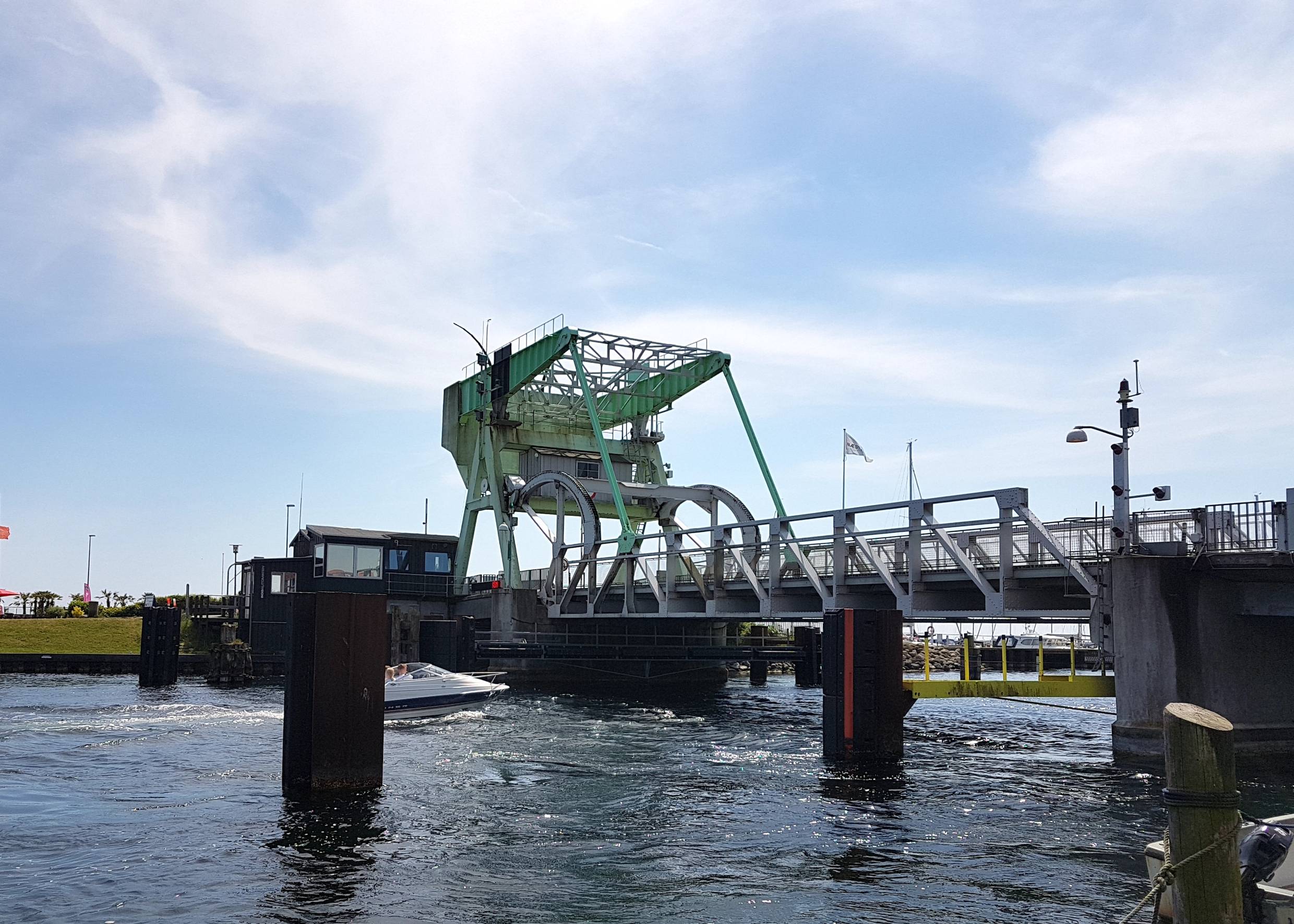 Hellgrüne Stahlbrücke über einen schmalen Kanal