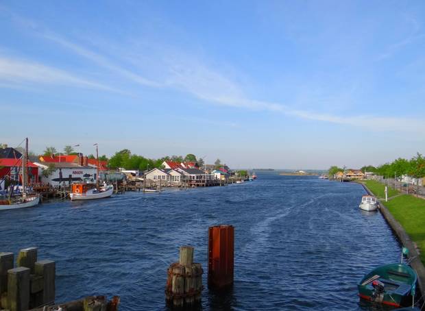 Blick auf Gastronomie und Fischerboote am Ufer eines Kanals