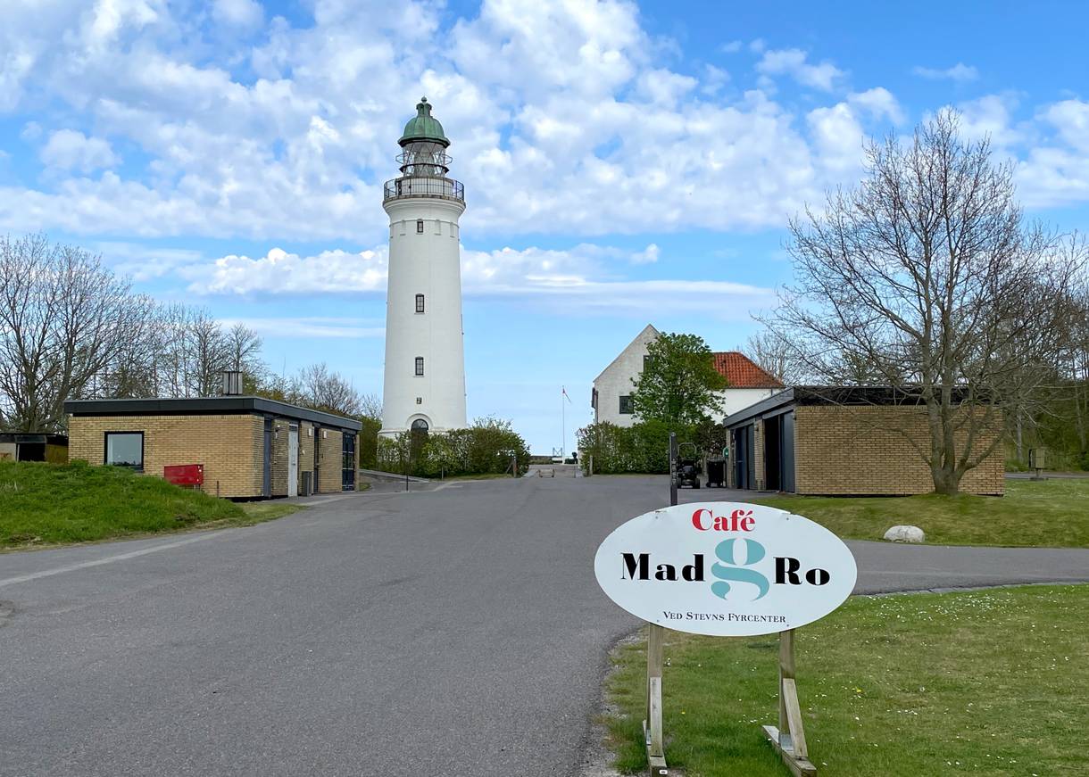 Zufahrt zu einem Leuchtturm, am Weg ein Hinweis auf ein Restaurant