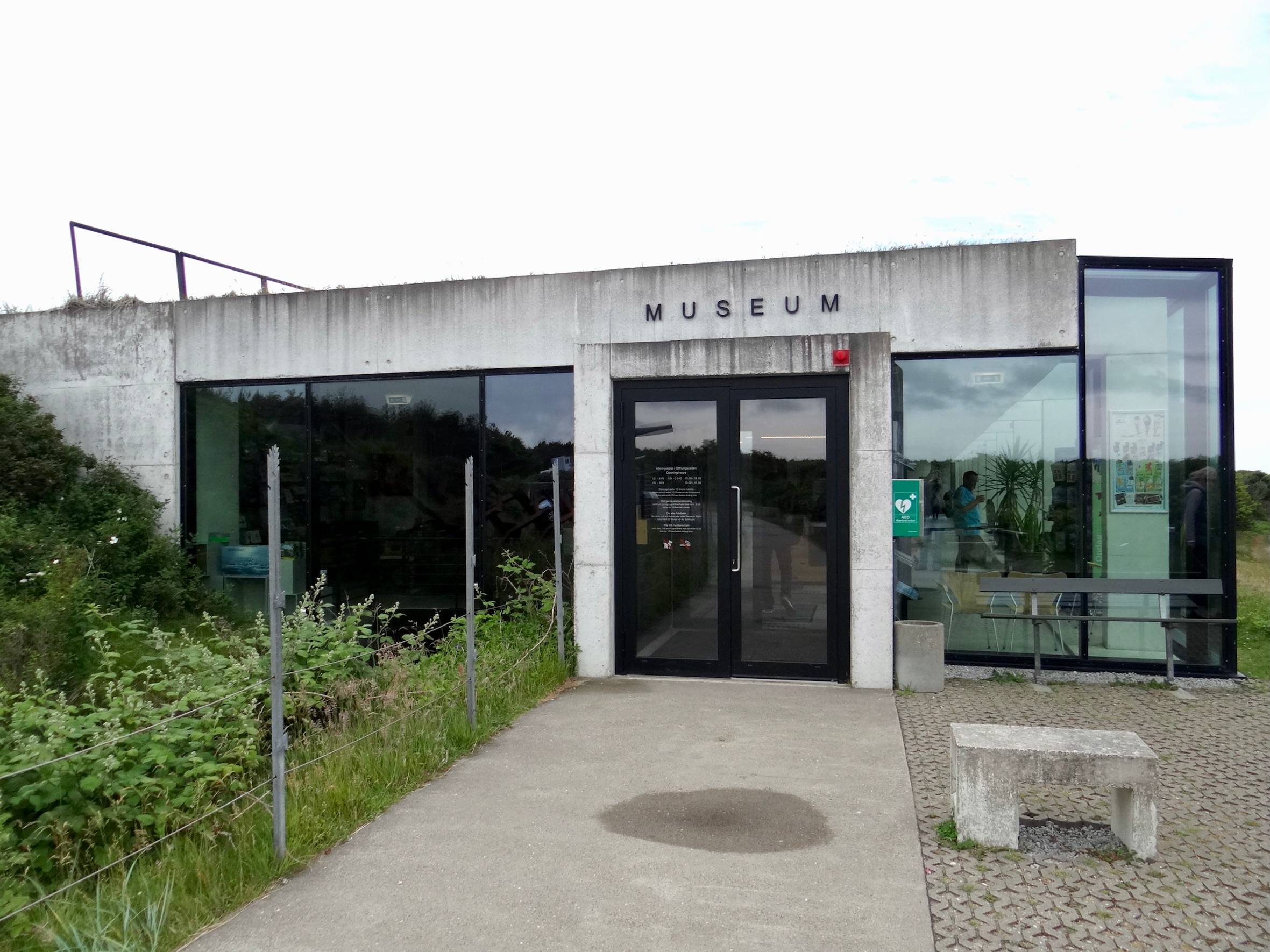Flaches Museumsgebäude aus Beton und Glasfronten