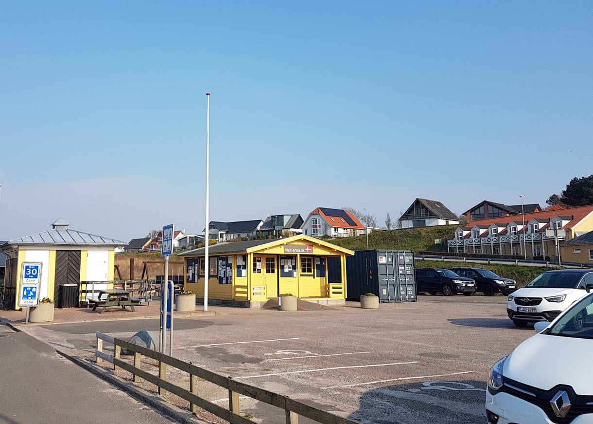 Gelbes Holzhäuschen an einem Parkplatz