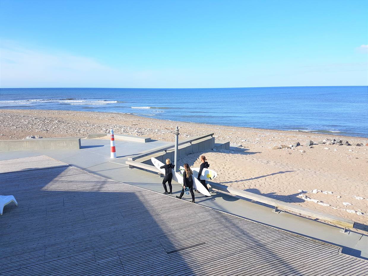 Surfer mit Boards unter dem Arm auf dem Weg zum Wasser