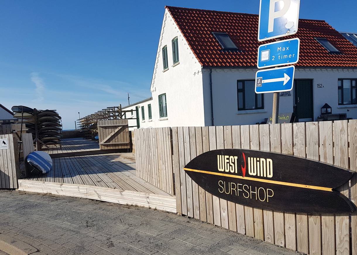 Hinweisschild zu einer Surfschule im Hinterhof