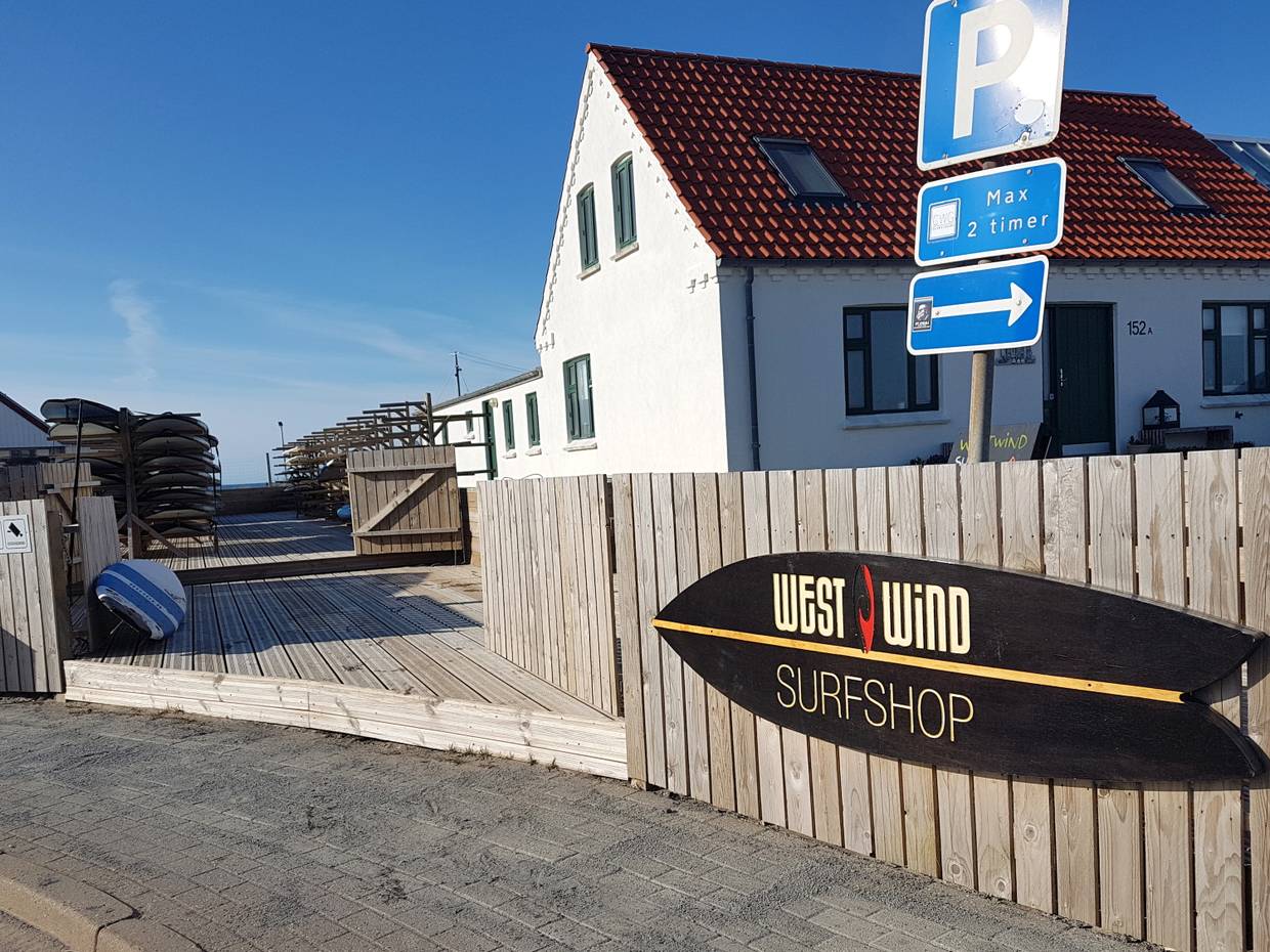 Hinweisschild zu einer Surfschule im Hinterhof