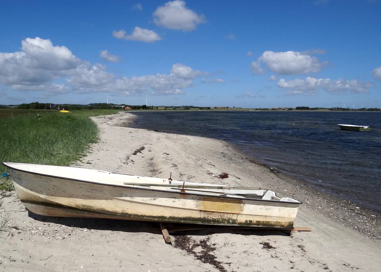 Ruderboot auf einem schmalen Sandstrand