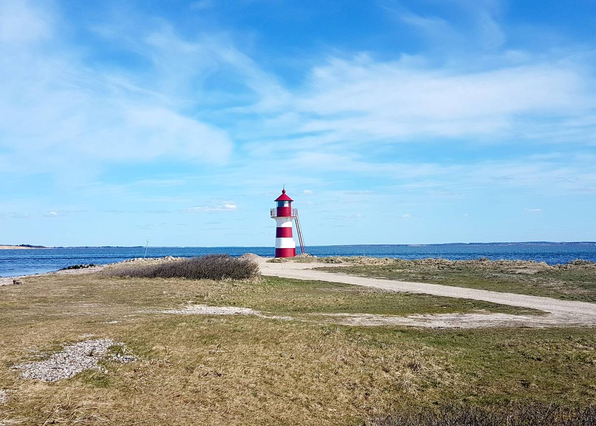 Rot-weißer Leuchtturm vor blauem Himmel