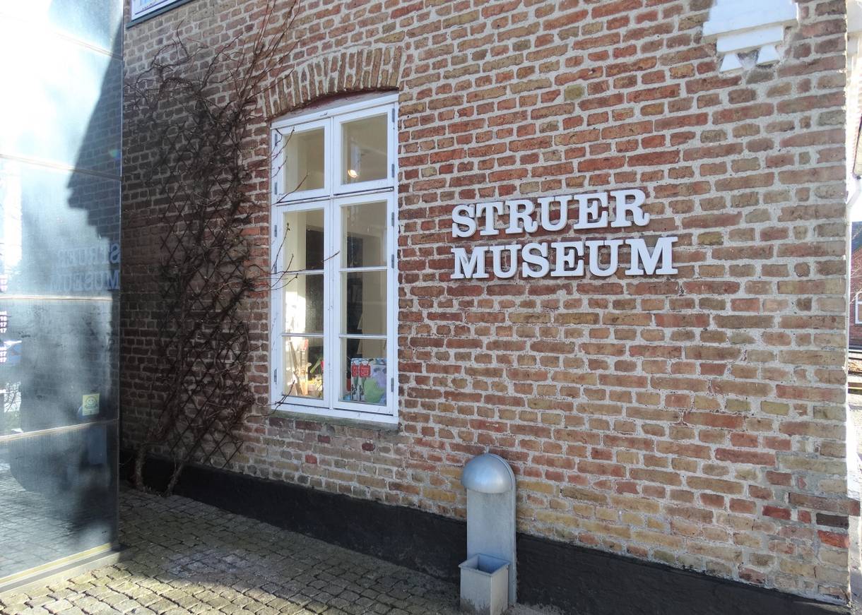 Schriftzug "Struer Museum" an einem alten Backsteinhaus mit weißem Fenster