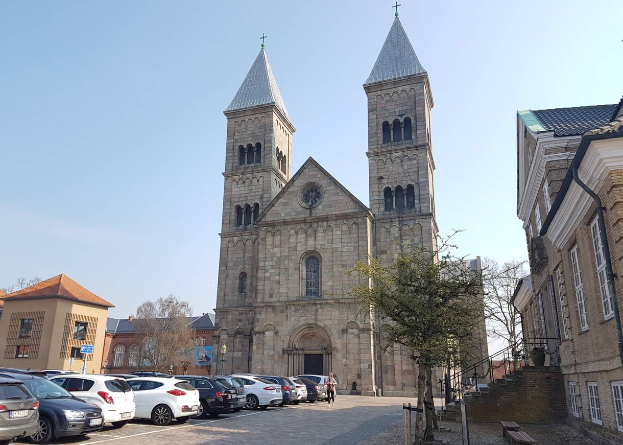 Portal der Domkirche Viborg mit zwei viereckigen Türmen, davor ein Parkplatz