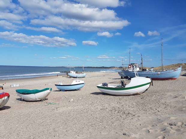 Strandstück mit blau-weißen Fischerbooten am Strand