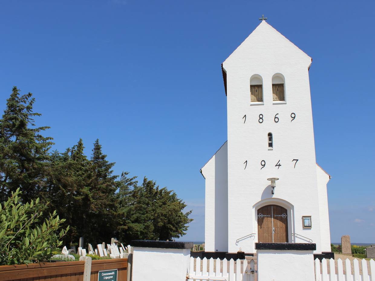 Weiße Strandkirche am Fjordufer