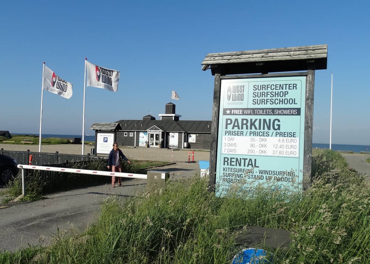 Einfacht zu einer Surfschule, an der Schranke ein Schild mit allen Angeboten