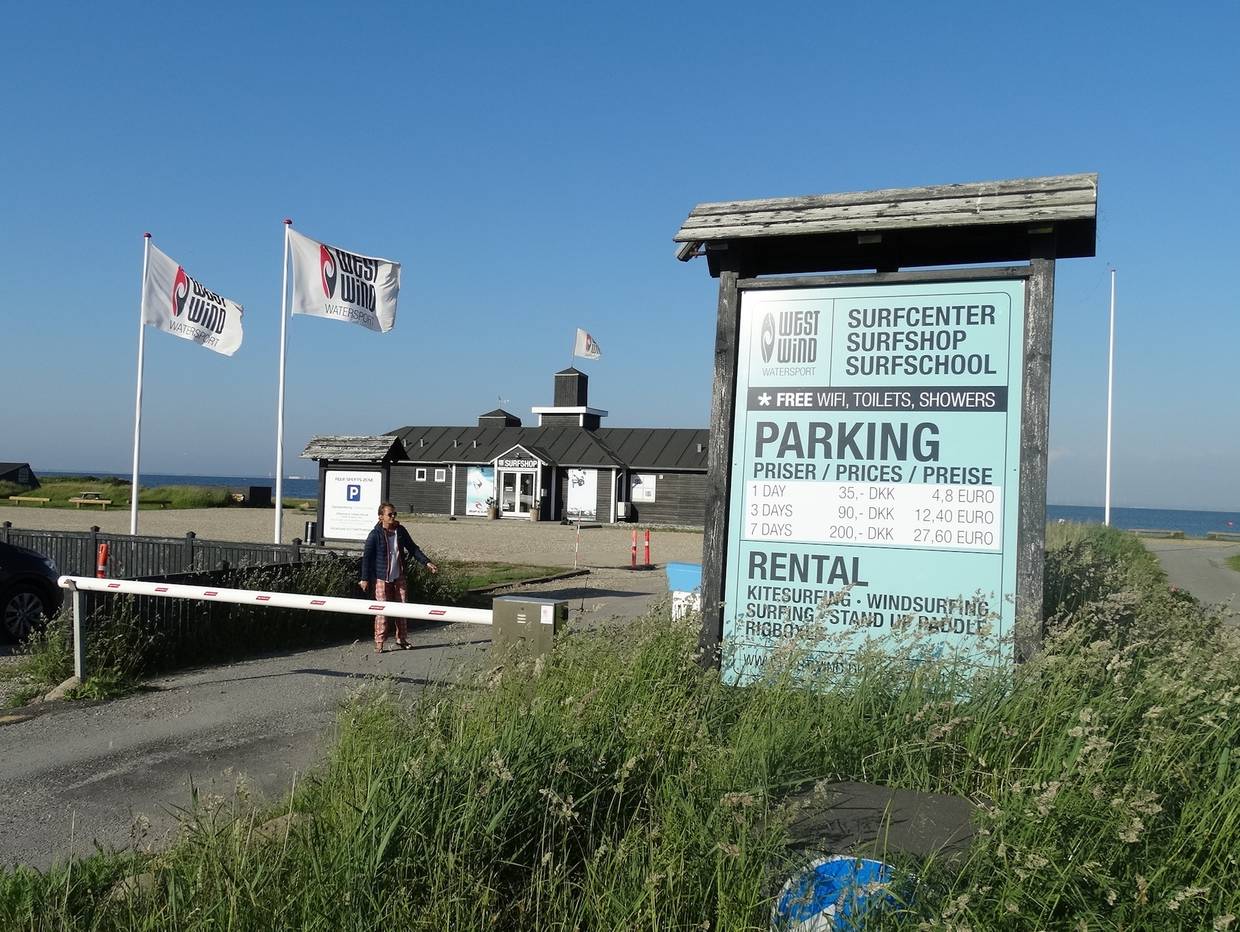 Einfacht zu einer Surfschule, an der Schranke ein Schild mit allen Angeboten