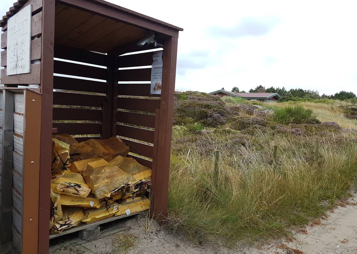 Holzverschlag, in dem Brennholz zum Verkauf liegt