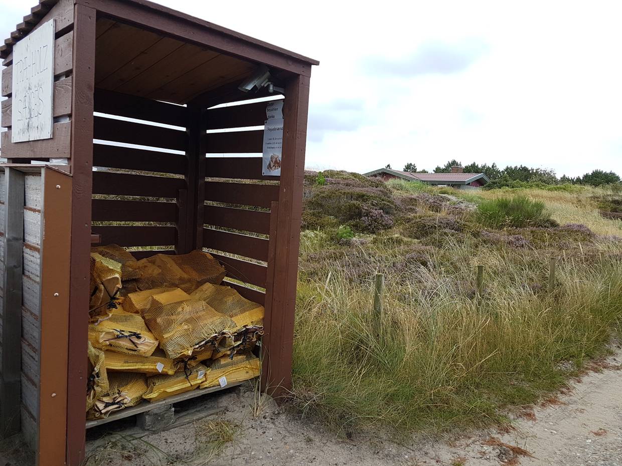 Holzverschlag, in dem Brennholz zum Verkauf liegt