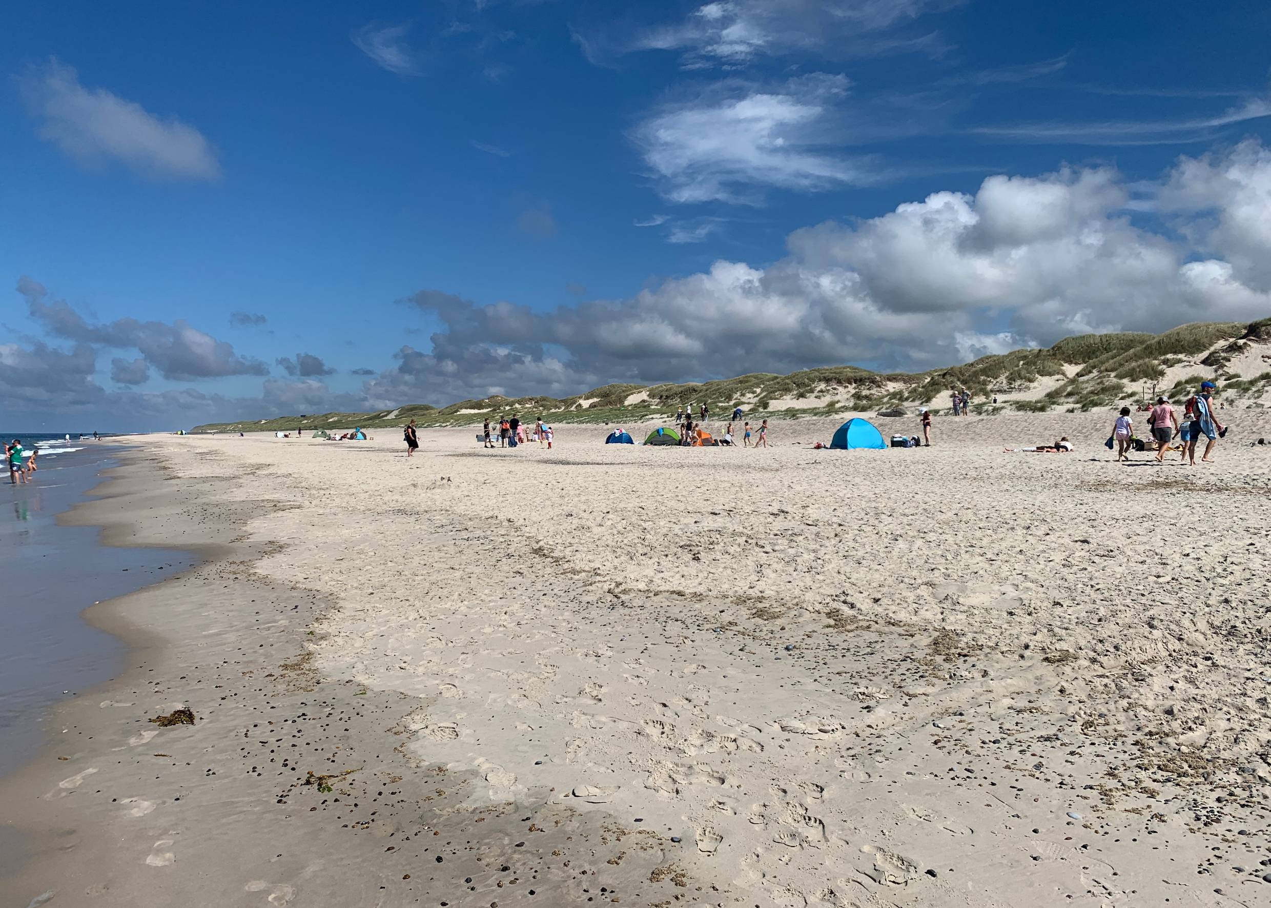 Spaziergänger am Strand im Gegenlich