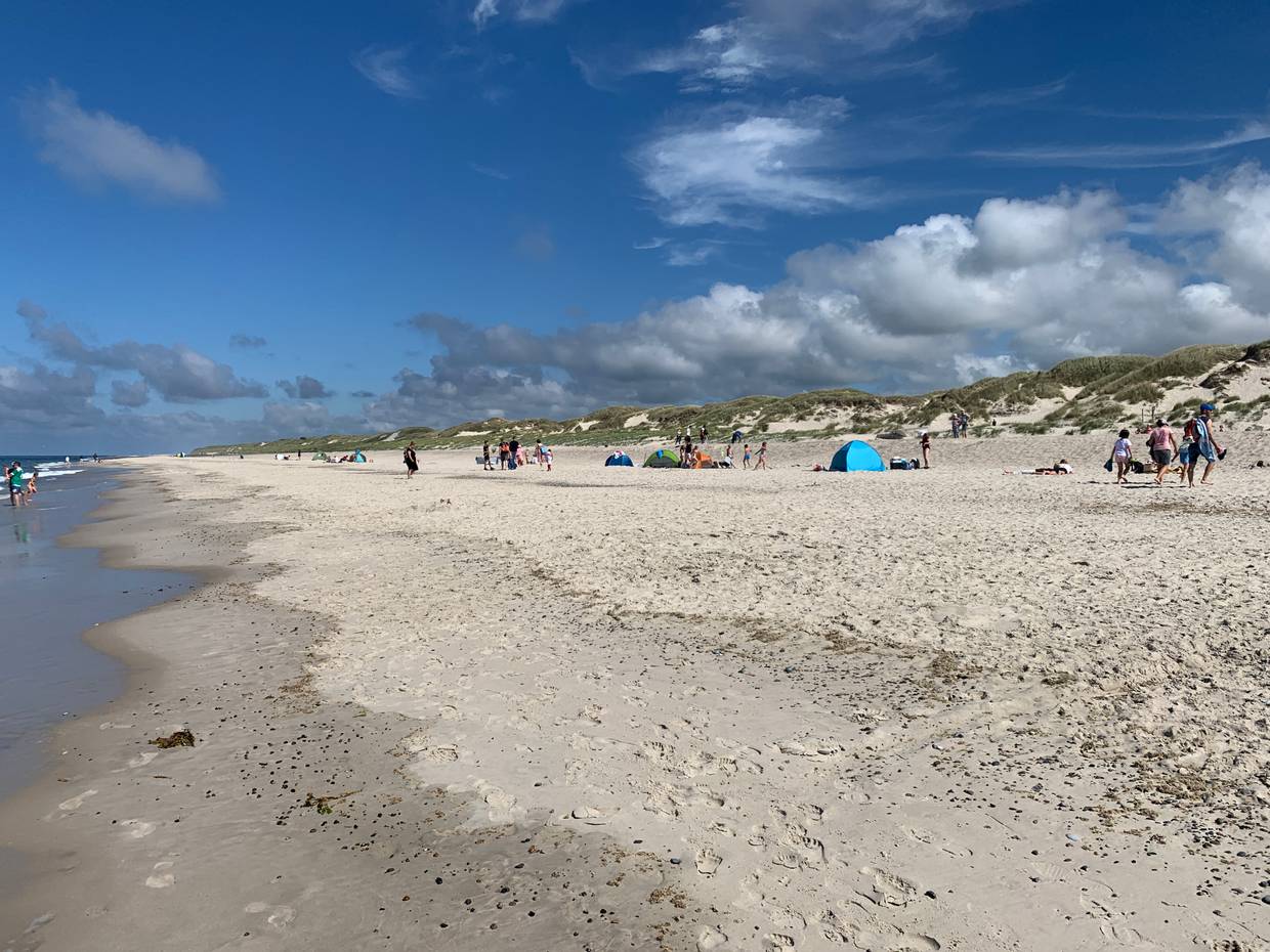 Spaziergänger am Strand im Gegenlich