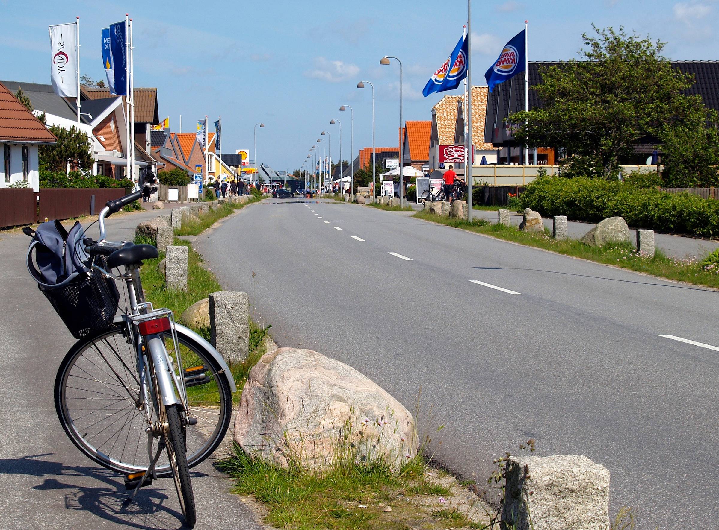 Hauptstraße mit vielen Geschäften im Vordergrund ein Fahrrad
