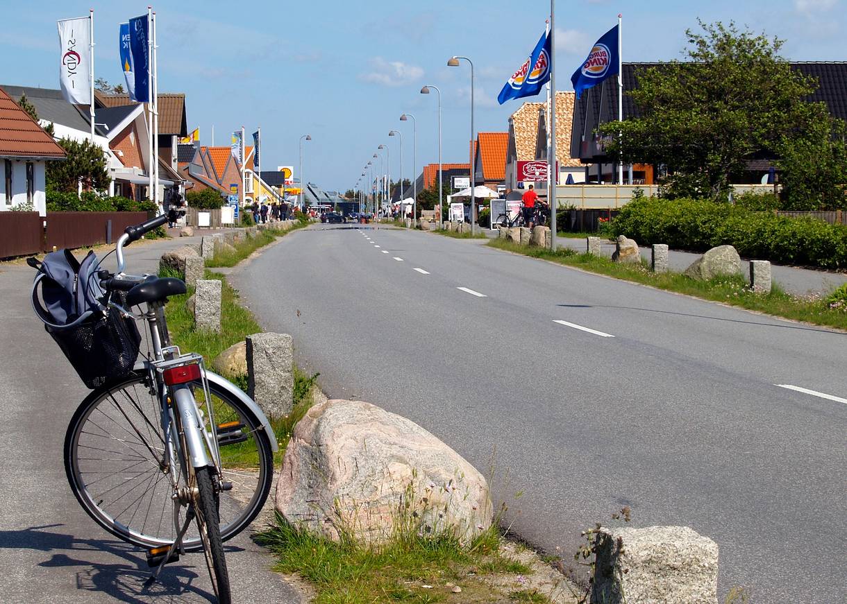 Hauptstraße mit vielen Geschäften im Vordergrund ein Fahrrad