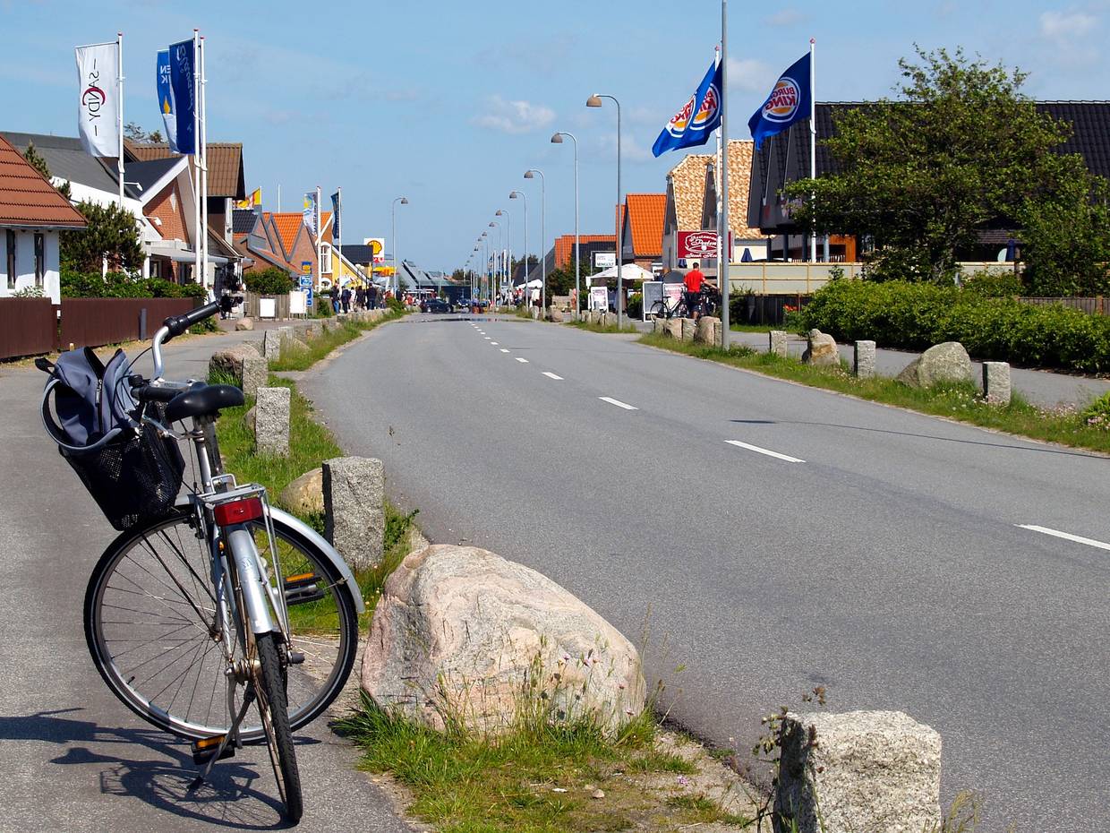 Hauptstraße mit vielen Geschäften im Vordergrund ein Fahrrad