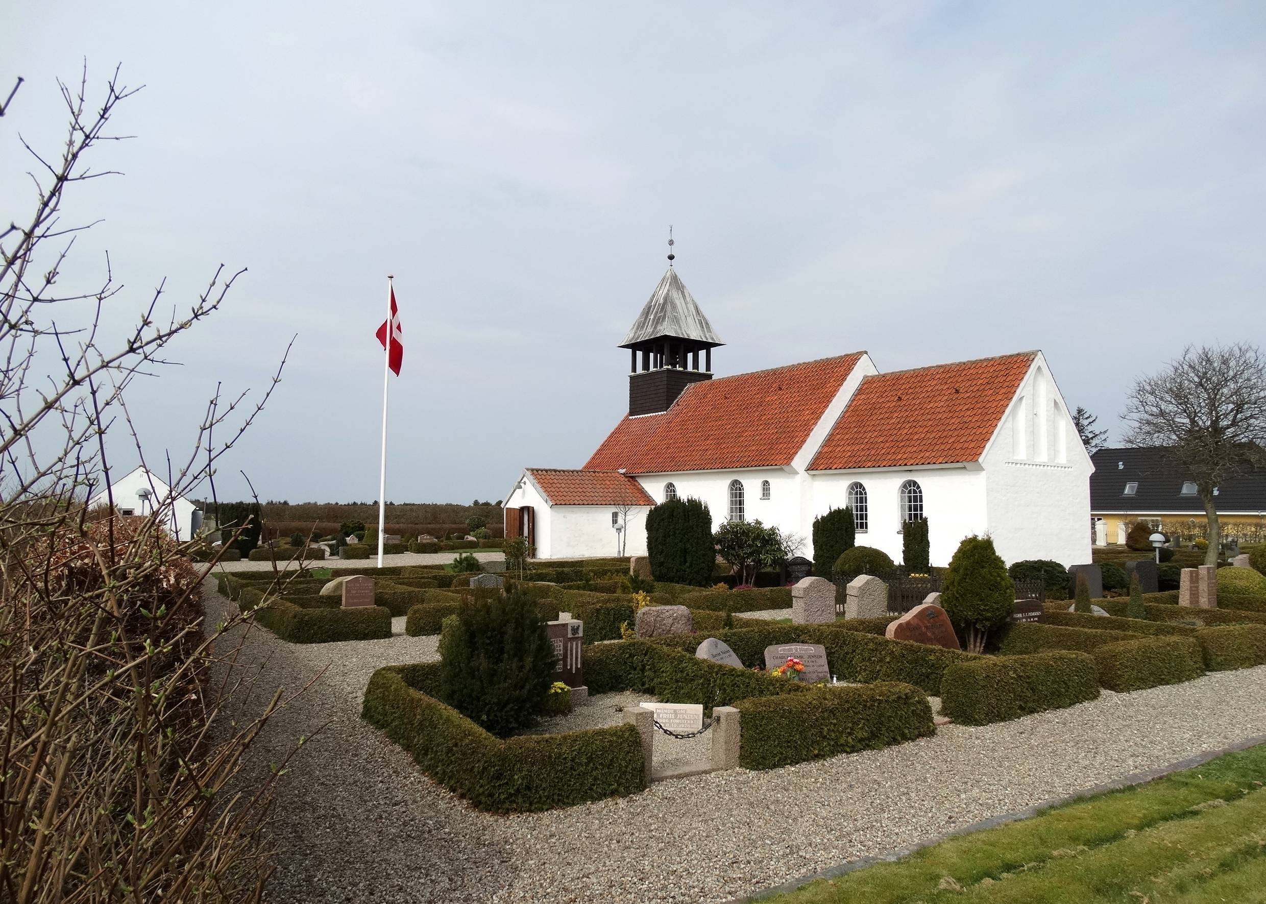 Weißes Kirche mit kleinem Friedhof