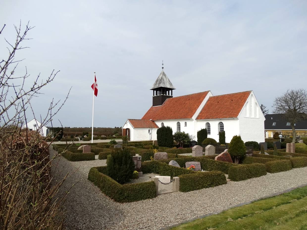 Weißes Kirche mit kleinem Friedhof