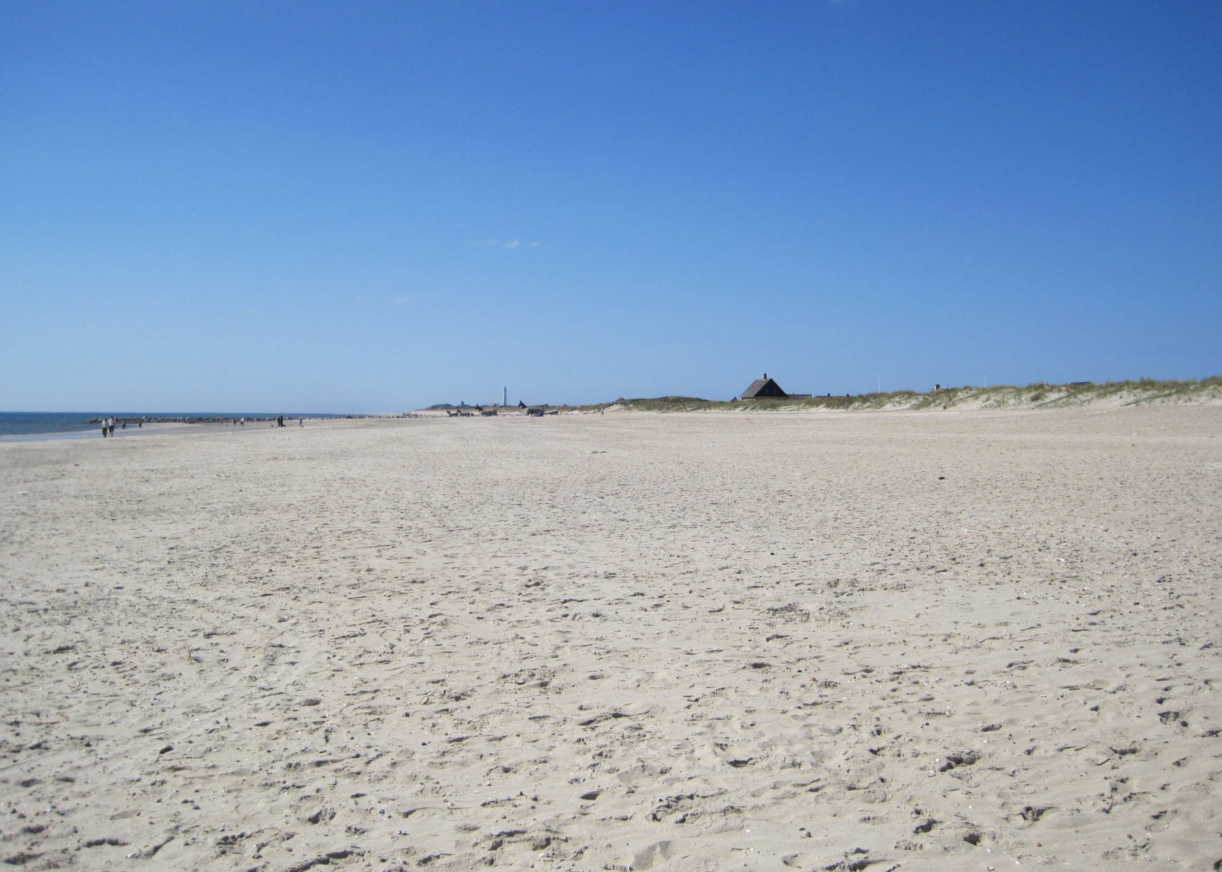 Der Strand von Blåvand mit dem Leuchtturm und den Pferdebunkern in der Ferne