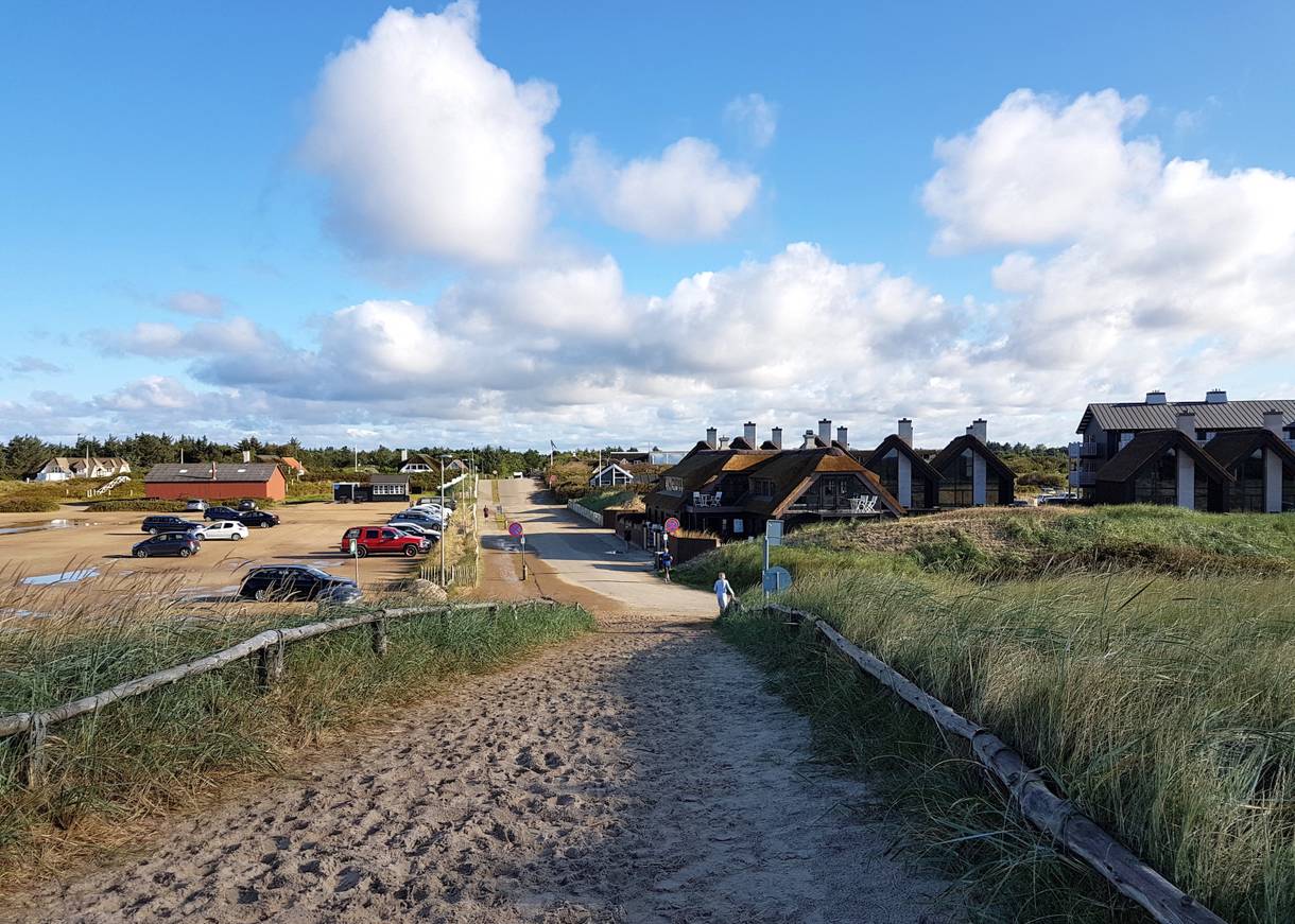Blick von der Düne auf den Parkplatz und Ferienhäuser