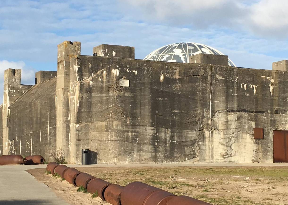 Graue, großer Bunker, aus dem eine moderne Kuppel aufragt