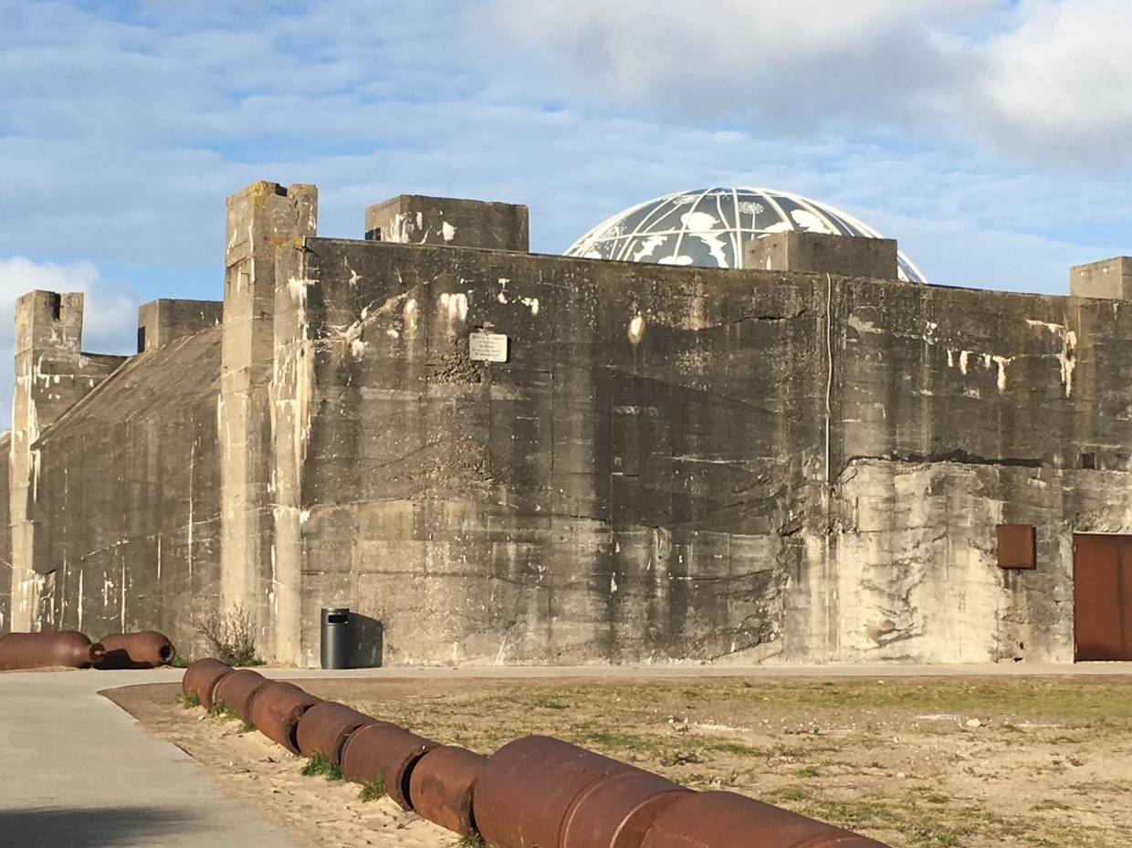 Graue, großer Bunker, aus dem eine moderne Kuppel aufragt