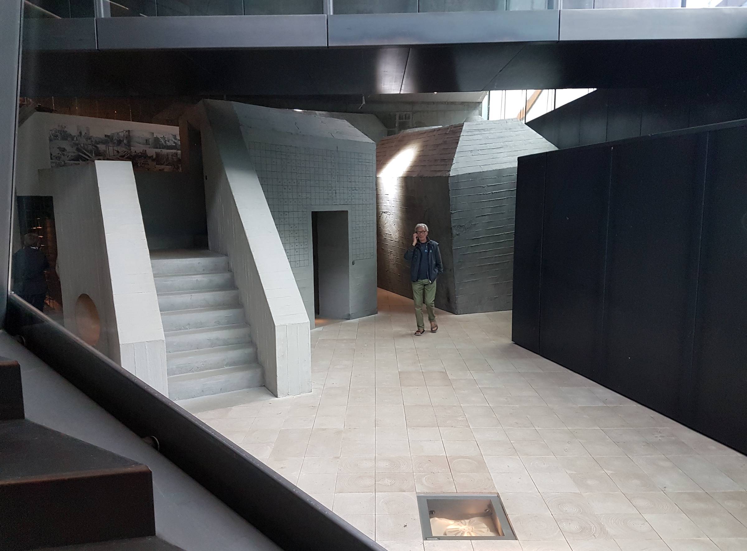 Ein Besucher zwischen grauen Mauern im Museum