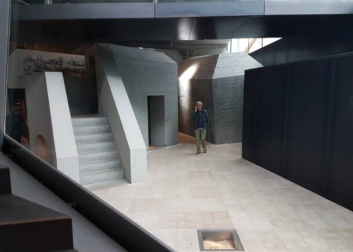 Ein Besucher zwischen grauen Mauern im Museum