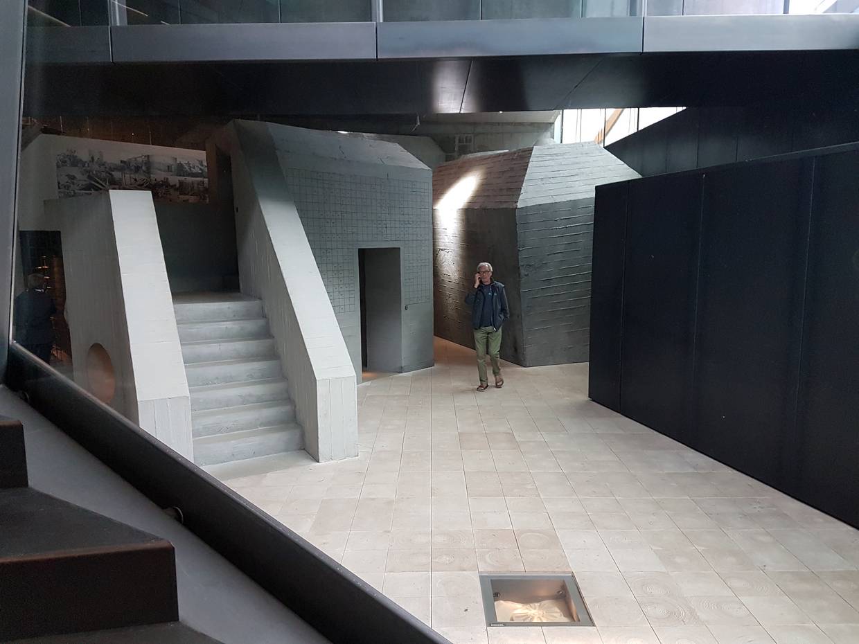 Ein Besucher zwischen grauen Mauern im Museum