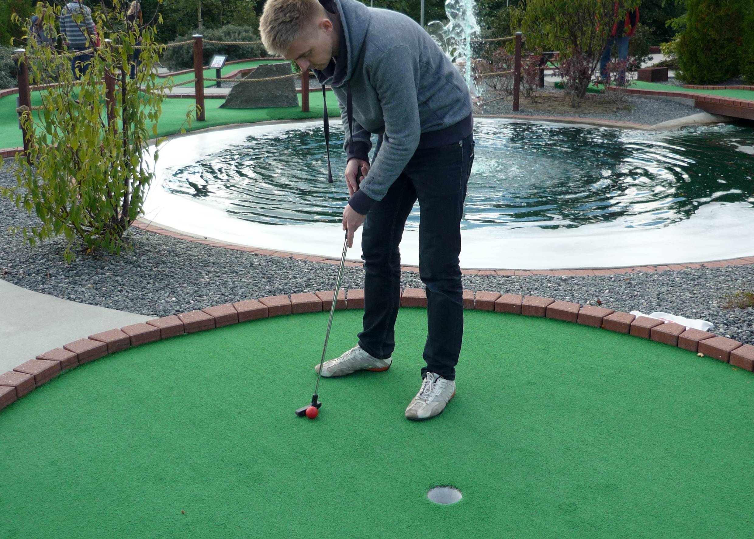 Junger Mann mit Minigolfschläger