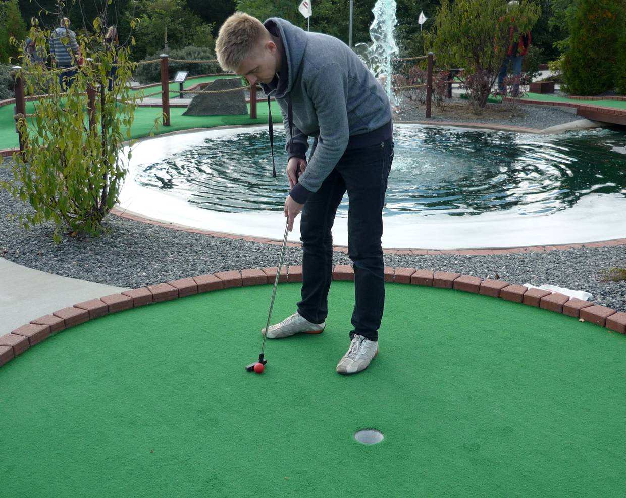 Junger Mann mit Minigolfschläger