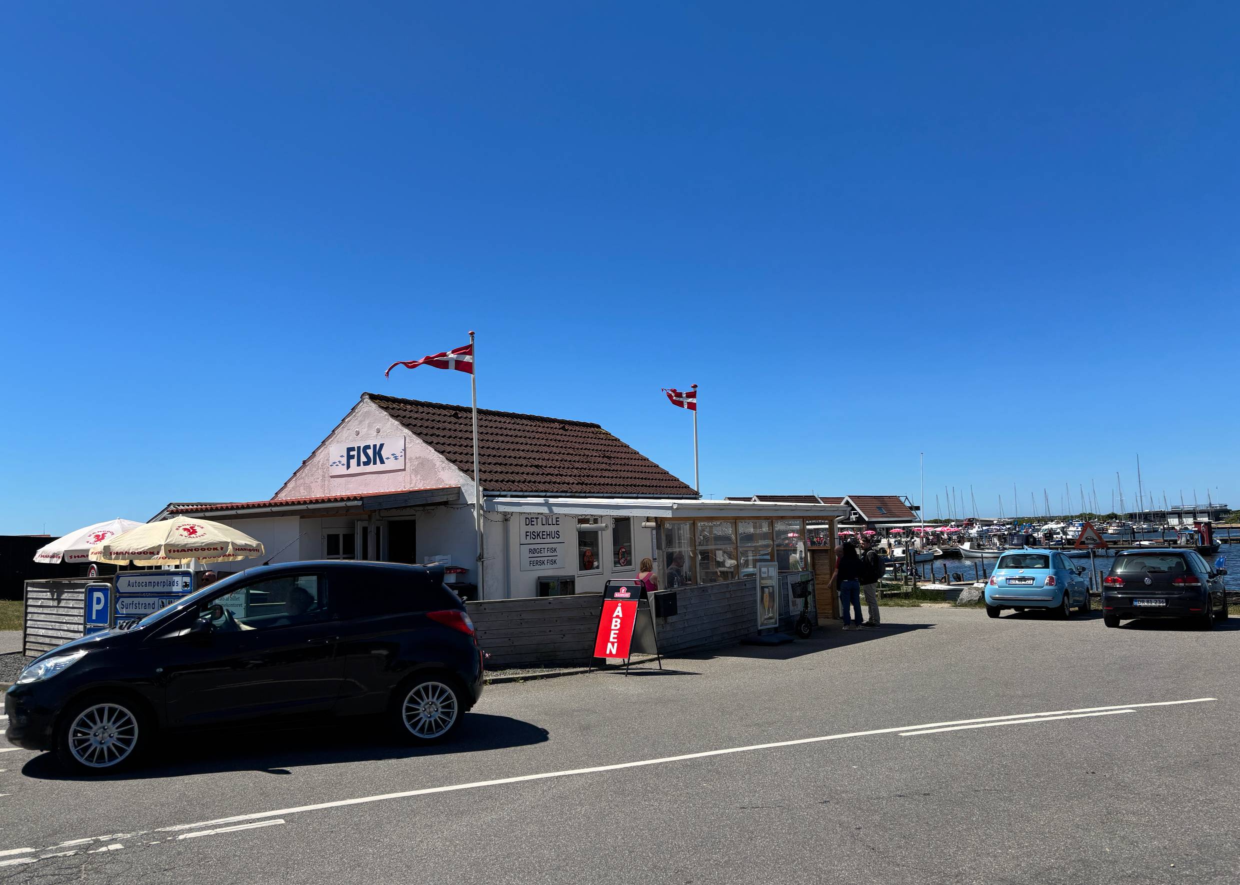 Kleines weißes Gebäude mit der Aufschrift Fisk am Hafen