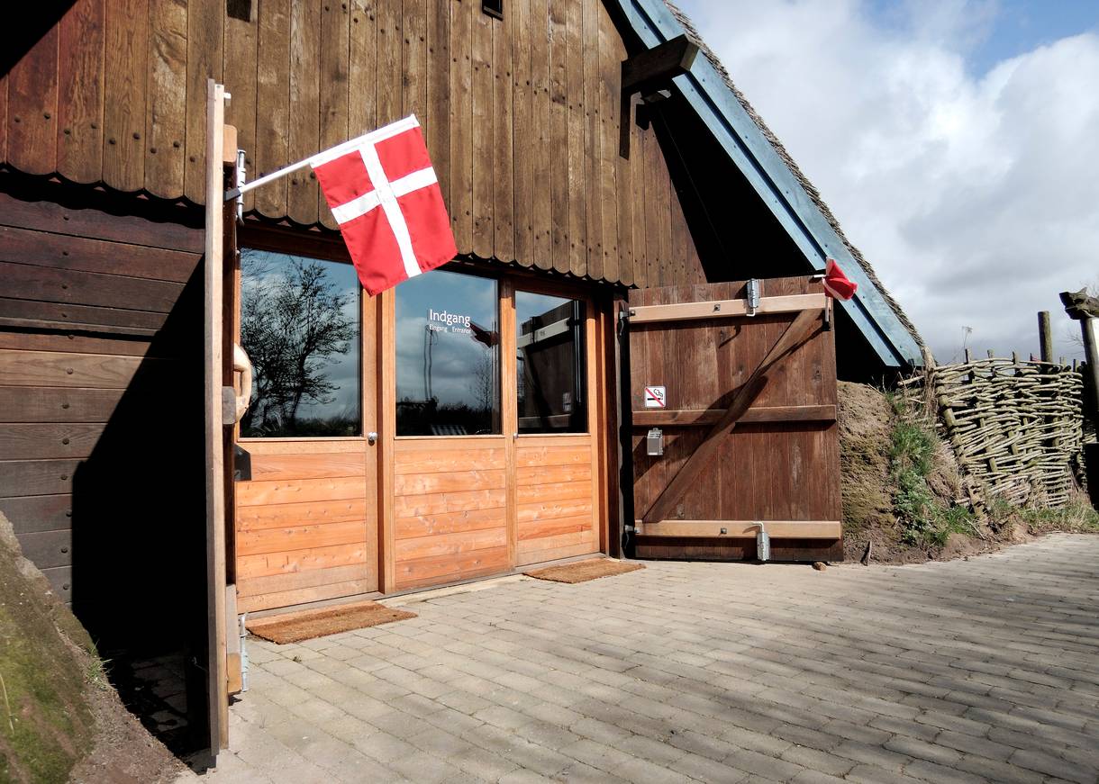 Eingang an einem Holzgebäude mit Dannebrog an der Tür