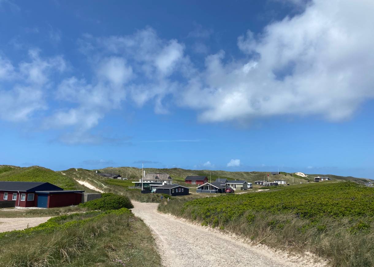 Ein paar vereinzelte Ferienhäuser unter blauem Himmel