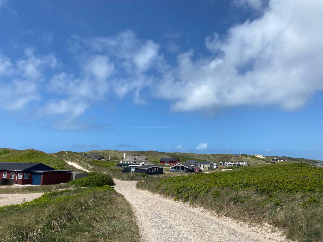 Ein paar vereinzelte Ferienhäuser unter blauem Himmel