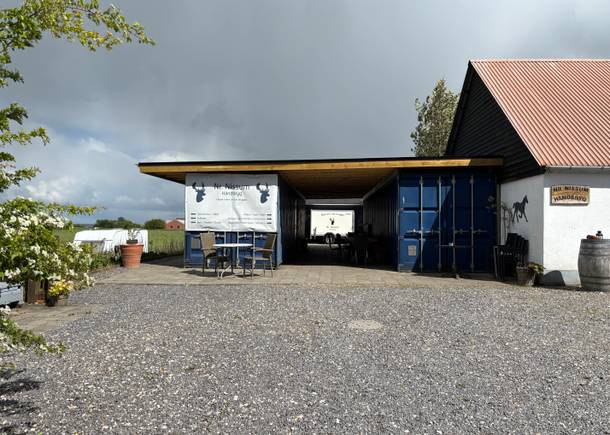 Hof mit zwei blaue Schiffscontainer und Schilder, die auf einer kleinen Brauerei hinweisen